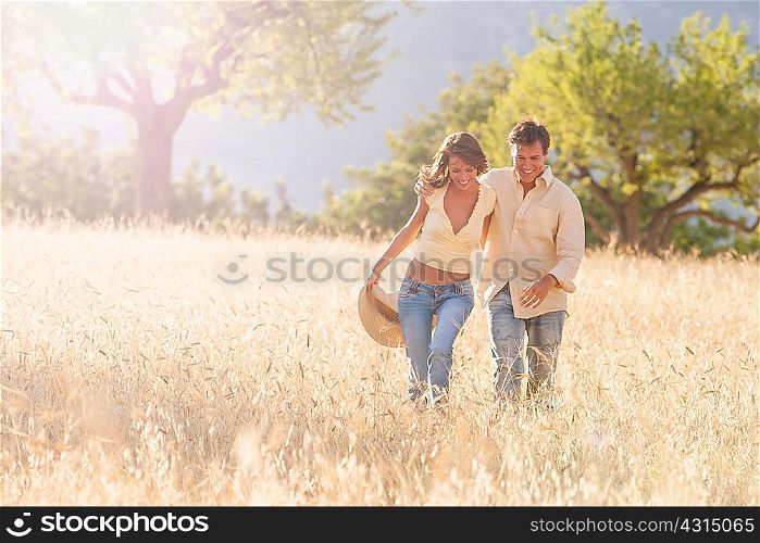 Romantic couple strolling in field of long grass, Majorca, Spain