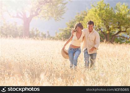 Romantic couple strolling in field of long grass, Majorca, Spain