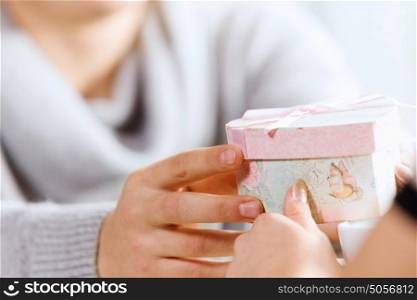 Romantic date. Close up image of hands presenting a box with surprise