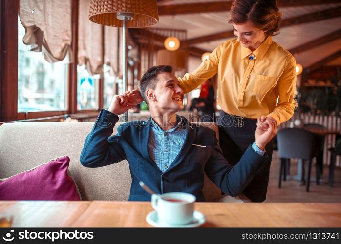 Romantic date of love couple in restaurant. Man in suit hugs beautiful woman. Romantic date of love couple in restaurant