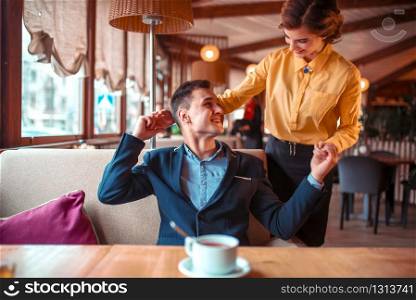 Romantic date of love couple in restaurant. Man in suit hugs beautiful woman. Romantic date of love couple in restaurant