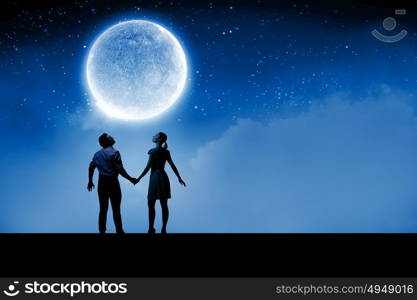 Romantic date. Silhouettes of couple against big moon at background