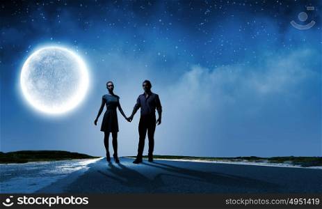 Romantic date. Silhouettes of couple against big moon at background