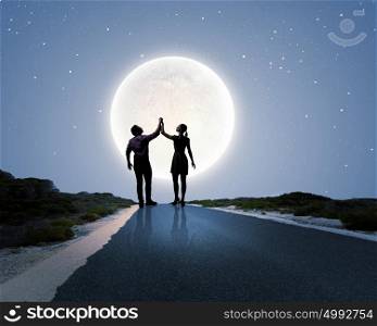 Romantic date. Silhouettes of couple against big moon at background
