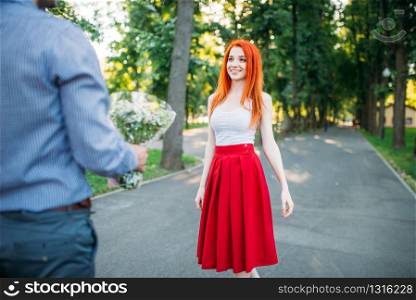 Romantic date, young couple meeting in green summer park. Man and woman leisure outdoors