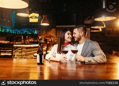 Romantic evening of couple in bar, date celebration. Lovers leisures in pub, husband and wife relaxing together in nightclub. Romantic evening, couple in bar, date celebration