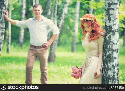 Romantic gentle bride posing near birch tree, handsome groom looking on her, beautiful young loving couple, happy wedding day concept