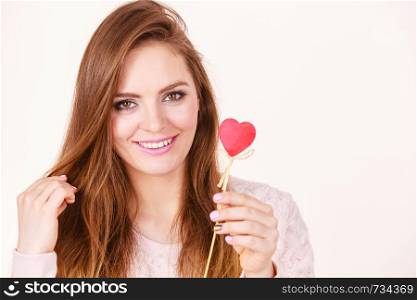 Romantic gestures, valentines gifts ideas concept. Happy flirty woman holding red wooden heart on stick.. Flirty woman holding red wooden heart on stick