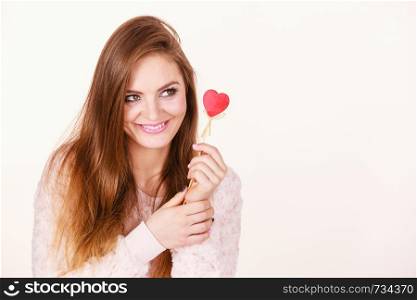 Romantic gestures, valentines gifts ideas concept. Happy flirty woman holding red wooden heart on stick.. Flirty woman holding red wooden heart on stick