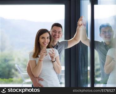 romantic happy young couple enjoying morning coffee by the window in their luxury home