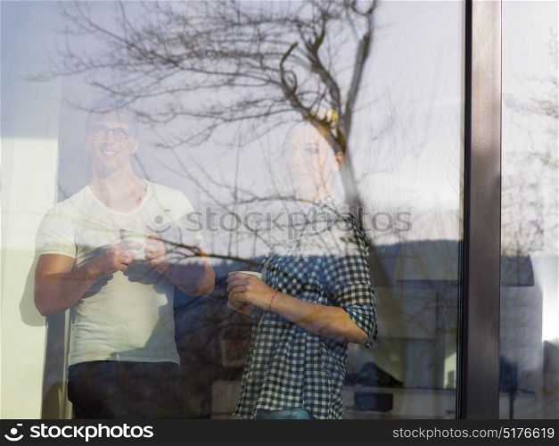 romantic happy young couple enjoying morning coffee by the window in their luxury home
