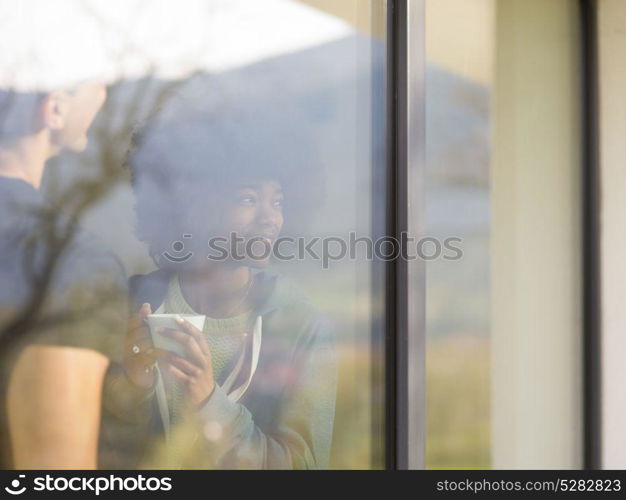 romantic happy young multiethnic couple enjoying morning coffee by the window in their luxury home