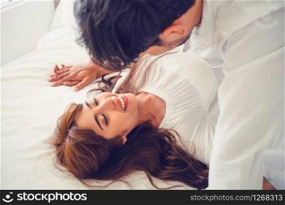 Romantic love of intimate young couple in home bedroom foreplay in the bed.