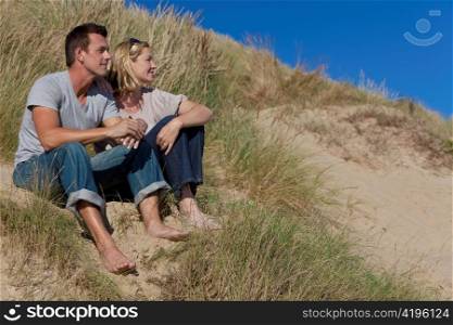 Romantic Man and Woman Couple Sitting Together On A Beach