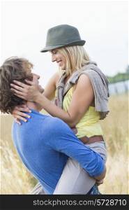 Romantic man carrying woman in field