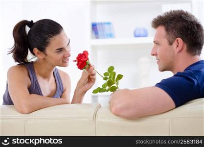 Romantic man giving red rose to woman - Valentine&acute;s Day.