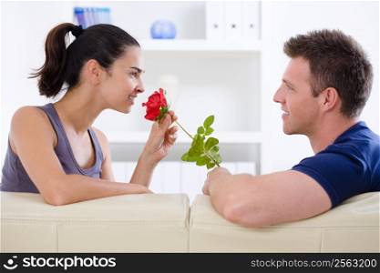 Romantic man giving red rose to woman - Valentine&acute;s Day.