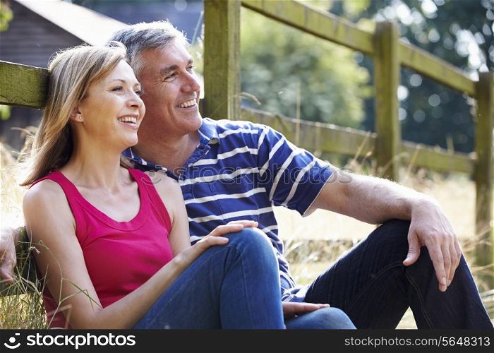 Romantic Middle Aged Couple Relaxing On Walk In Countryside