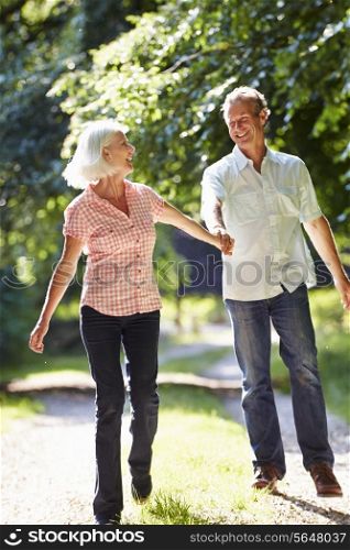 Romantic Middle Aged Couple Walking Along Countryside Path