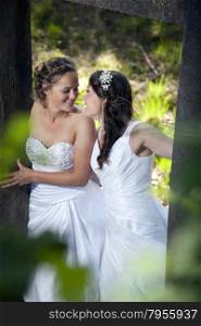 romantic picture of two smiling brides in nature surroundings