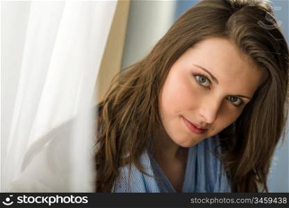 Romantic portrait beautiful woman brunette looking camera behind white curtain