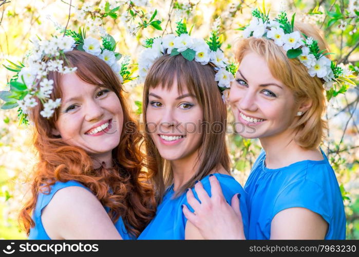 romantic portrait of three women at the time of flowering cherry in the park