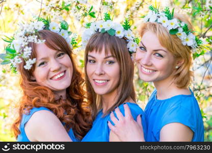 romantic portrait of three women at the time of flowering cherry in the park