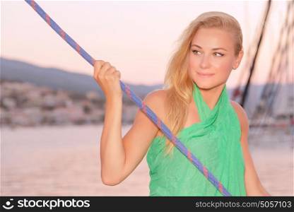 Romantic sea cruise, portrait of cute blond girl enjoying evening traveling on luxury sail boat, summer holidays concept