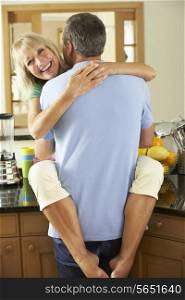 Romantic Senior Couple Hugging In Kitchen