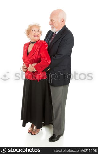 Romantic senior husband holds his wife close as they dance together. Full body isolated.