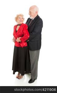 Romantic senior husband holds his wife close as they dance together. Full body isolated.