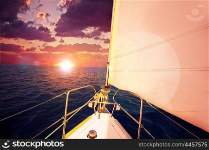 Romantic sunset and sail boat, dramatic sky with purple clouds and sun flare over calm sea, water sport, travel and freedom concept