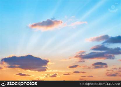 Romantic sunset with beautiful blue, red and yellow clouds and sun rays