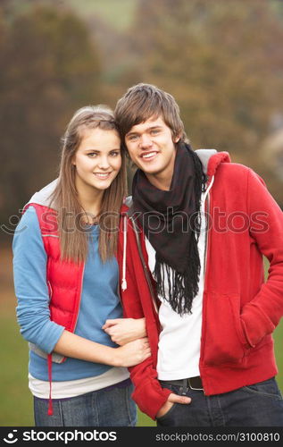 Romantic Teenage Couple Walking Through Autumn Landscape