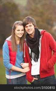 Romantic Teenage Couple Walking Through Autumn Landscape