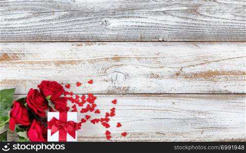 Romantic Valentines Day celebration with gifts in lower left corner of white rustic wood