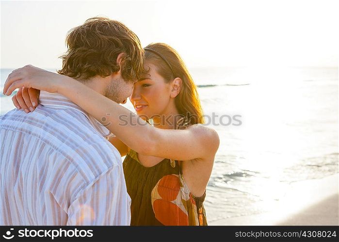 Romantic young couple face to face on sunlit beach, Majorca, Spain