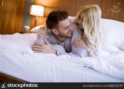 Romantic young couple in love lying in bed at home together
