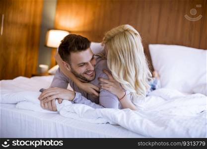 Romantic young couple in love lying in bed at home together