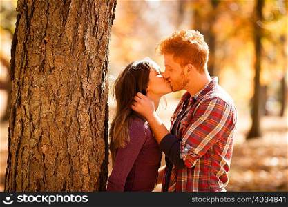 Romantic young couple kissing in autumn forest