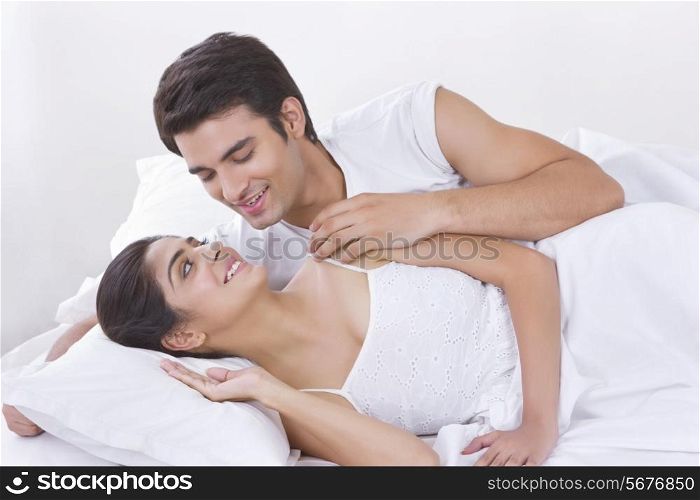 Romantic young couple looking at each other in bed