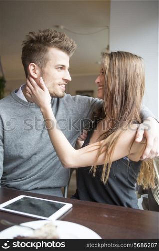 Romantic young couple looking at each other in cafe