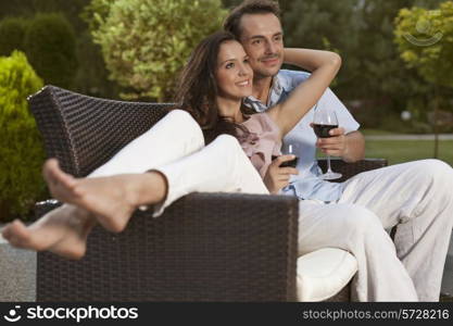 Romantic young couple on easy chair looking away in park