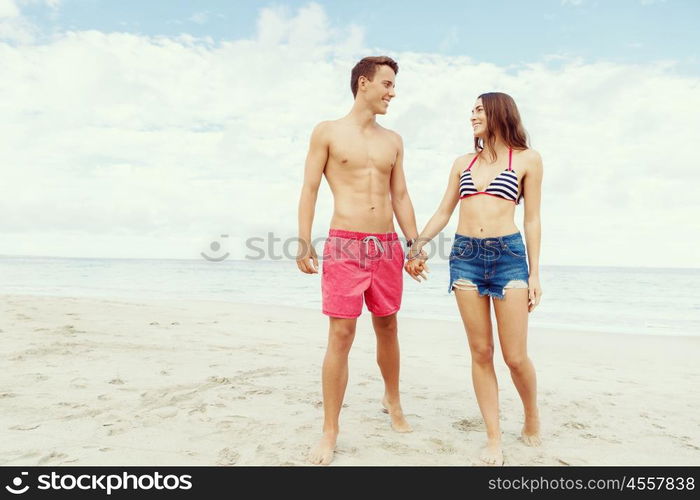 Romantic young couple on the beach. Portraits of romantic young couple standing on the beach