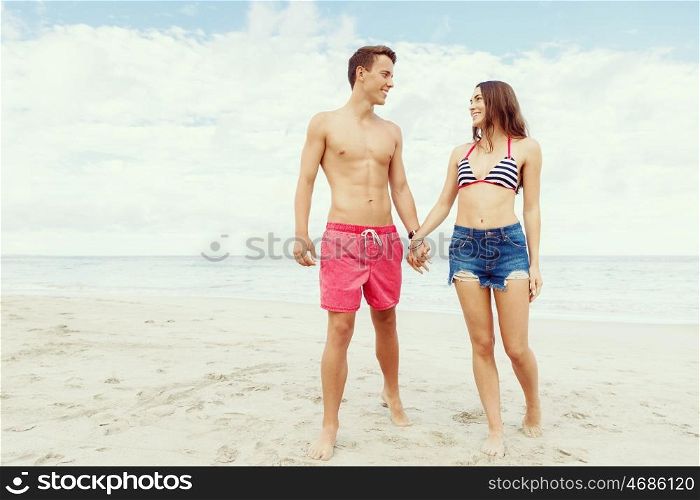 Romantic young couple on the beach. Portraits of romantic young couple standing on the beach
