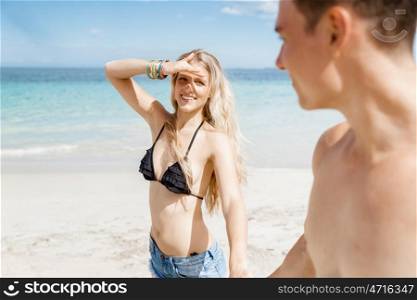 Romantic young couple on the beach. Portraits of romantic young couple walking on the beach