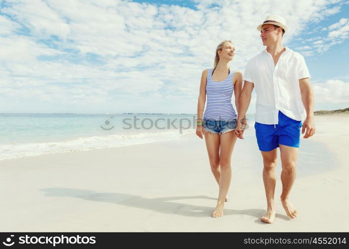 Romantic young couple on the beach. Romantic young couple on the beach walking along the shore