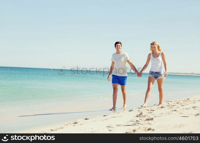 Romantic young couple on the beach. Romantic young couple on the beach walking along the shore