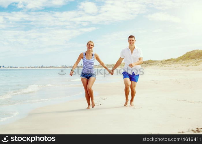 Romantic young couple on the beach. Romantic young couple on the beach running along the shore