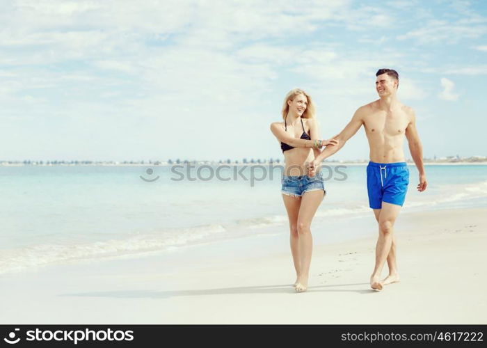 Romantic young couple on the beach. Romantic young couple on the beach walking along the shore